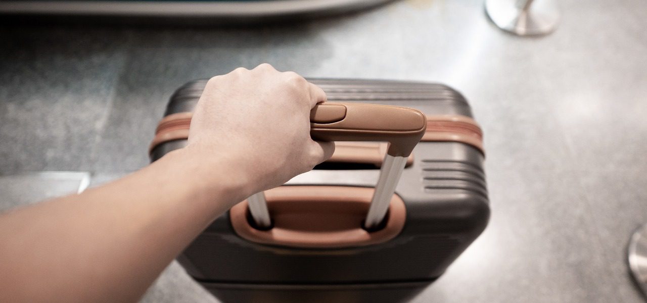 a man holding a suitcase at an airport